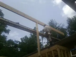 Carpenter setting a ridge beam over a new addition frame — Ice Dam Removal by Roofing Brothers in Hutchinson