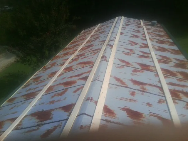 Rusted metal roof panels with new wood purlins before replacement — Storm Damage Roof Repair in Hutchinson by Roofing Brothers