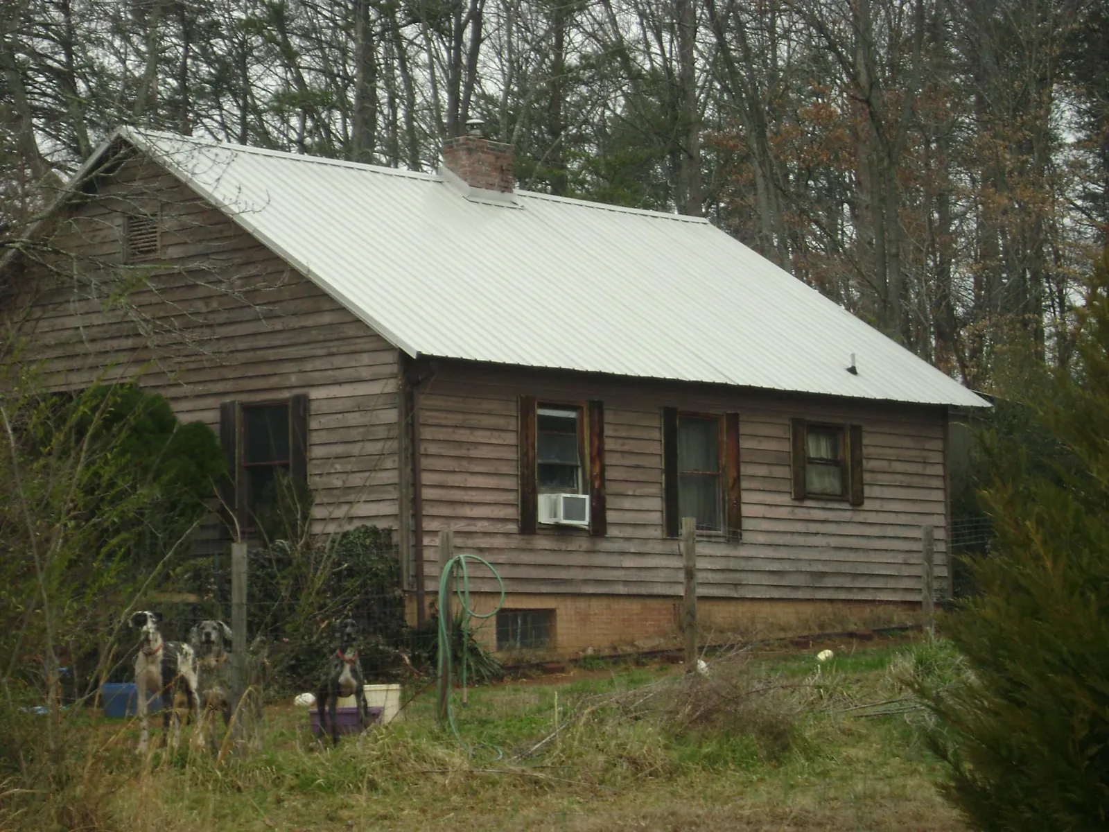 White metal roof on an old wood sided farmhouse, from a Metal Roof Installation job in Hutchinson